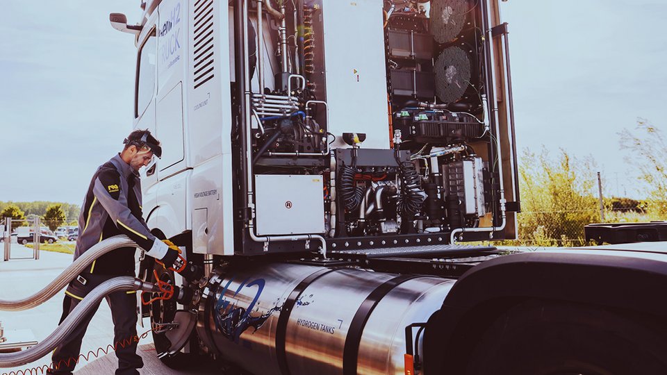 An employee refuels the Daimler GenH2 truck with hydrogen at a filling station.