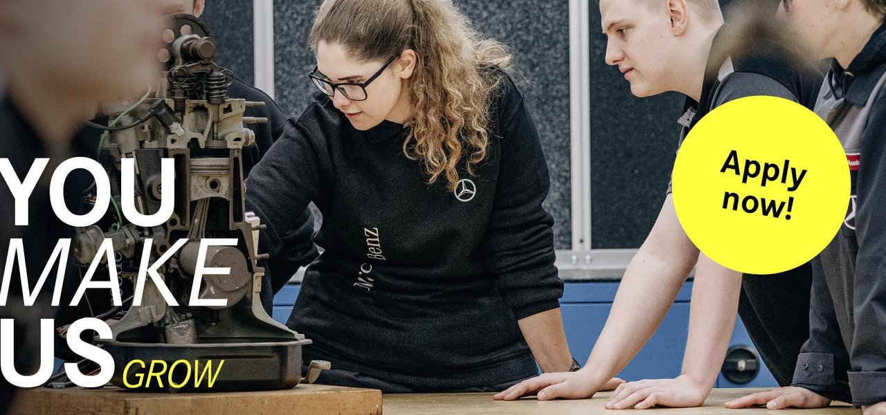 A group of young team members analyse a mechanical device in a workshop. The slogan "You make us grow" can be seen on the left-hand side, accompanied by a yellow button with "Apply now!"